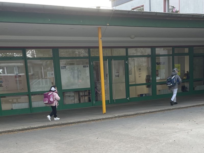 Überdachter Eingang der GGS Millrath mit Blick auf den Schulhof