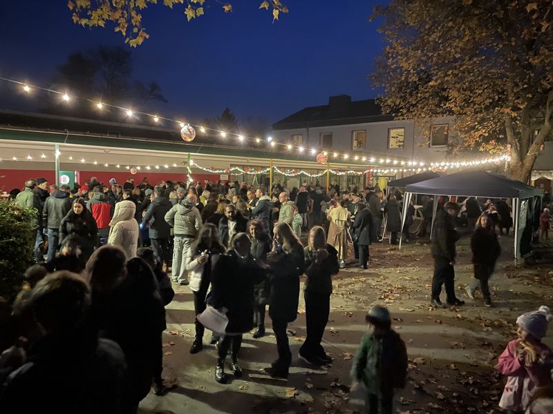 Martinszug am Abend: Kinder und Eltern unter Lichterketten auf dem Schulhof